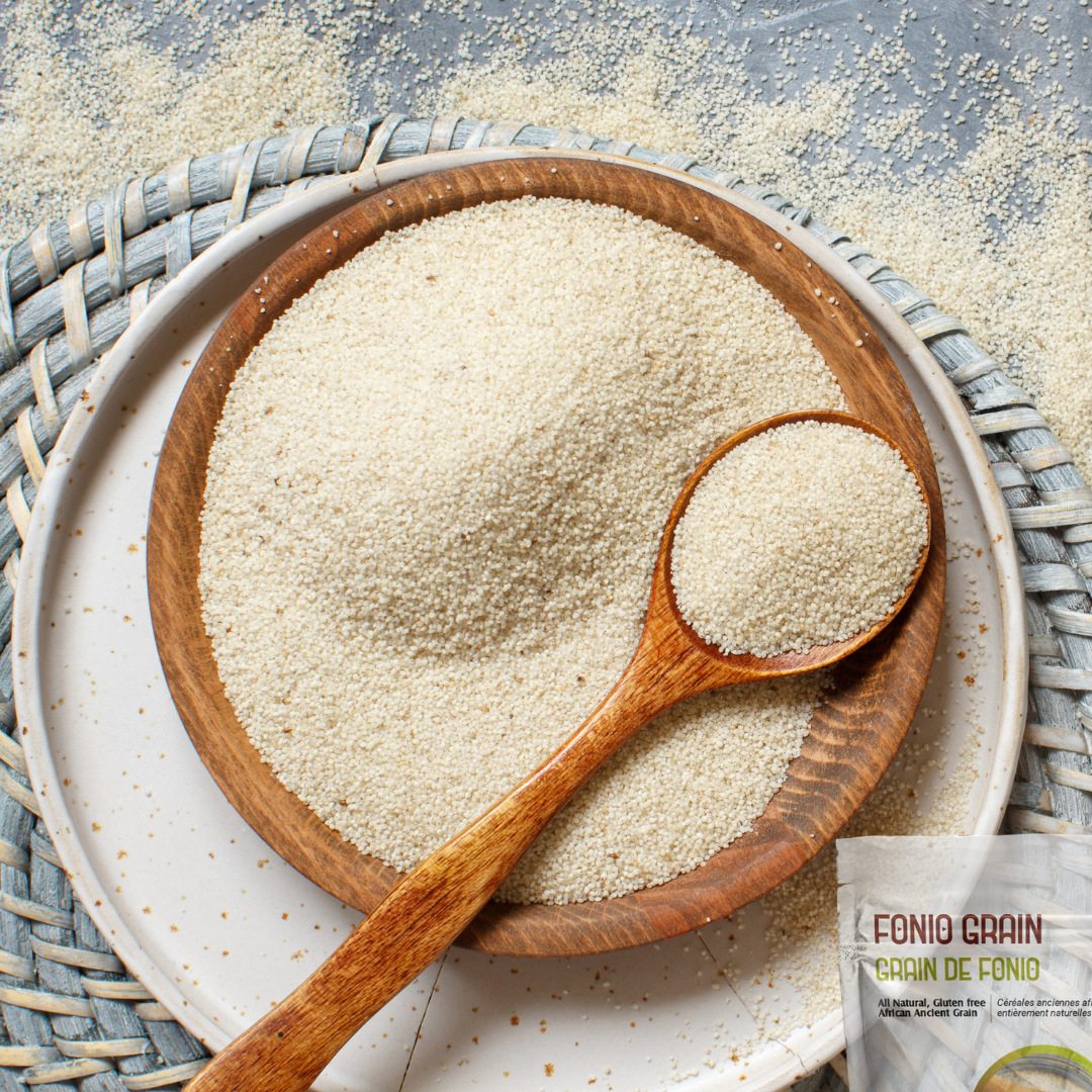 Wooden bowl and spoon filled with fonio grain on a textured surface